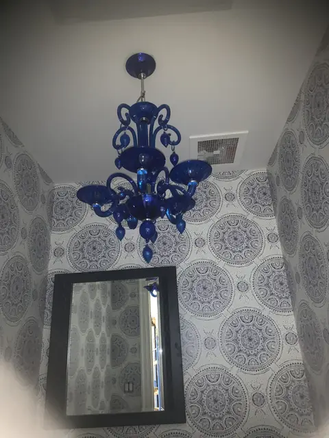 Candelabro de vidrio azul en un baño de visitas