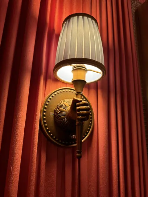 Aplique de pared junto a una cortina roja