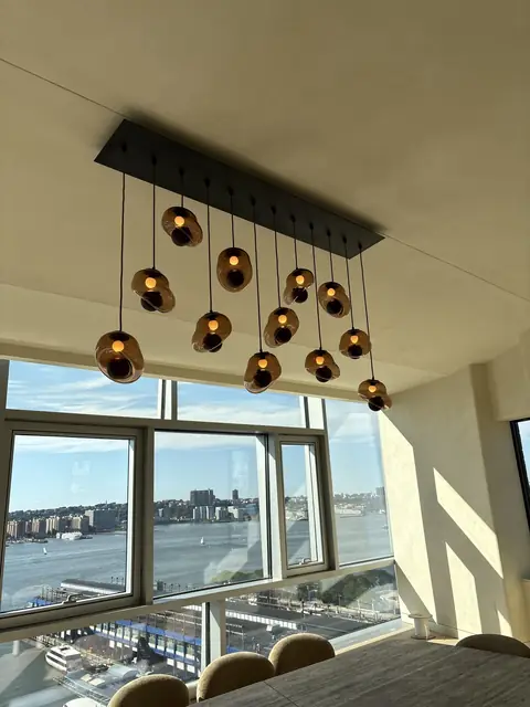 Lámparas colgantes sobre un comedor con vista al río